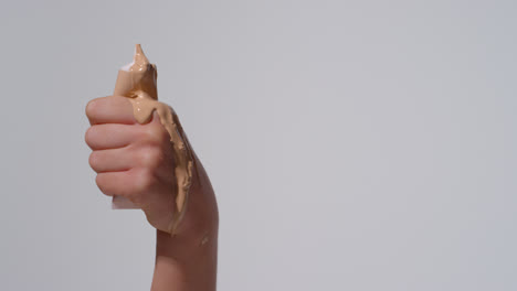 Close-Up-On-Woman-Holding-Tube-Of-Make-Up-After-Contents-Have-Been-Squeezed-Out-On-White-Background